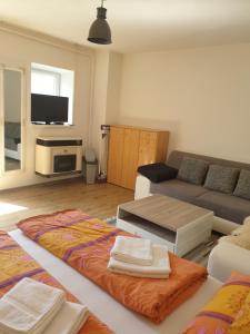 a living room with a couch and a table with towels at Wellness Villa Diana in Boldogkőváralja