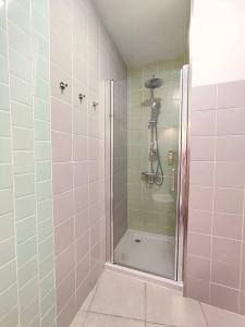 a shower in a bathroom with pink and green tiles at Arriaga Douro House in Peso da Régua