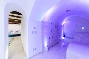 a white room with a purple tile wall at Dimora Bertella boutique & SpA in Amalfi