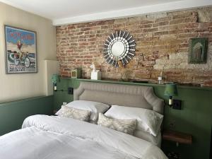 1 dormitorio con cama y pared de ladrillo en The Old Drum en Petersfield