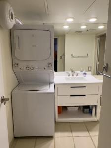 ein weißes Badezimmer mit einem Waschbecken und einem Spiegel in der Unterkunft Maalaea Harbor-Oceanfront 2 Bedroom/2 Bath in Wailuku