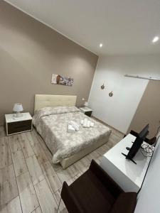 een slaapkamer met een bed en een bureau met een laptop bij Lucia's Rooms in Siracusa