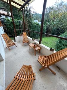 3 bancos de madera sentados en un balcón con vistas en Rincón Natural Urbano en San Salvador de Jujuy