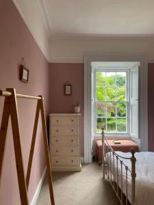a bedroom with a bed and a window and a dresser at Ashville Georgian House in Killinchy