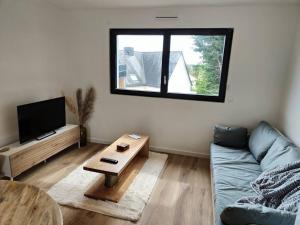 un soggiorno con un divano e un tavolino da caffè di Studio neuf proche centre-ville a Pabu