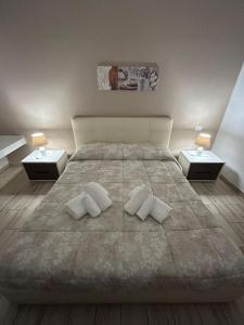 een slaapkamer met een groot bed met 2 nachtkastjes bij Lucia's Rooms in Siracusa