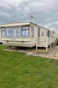 a yellow rv is parked in a field at Golden Anchor 8b9 Caravan Park Holiday Home in Chapel Saint Leonards