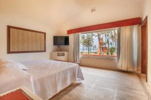 - une chambre avec un lit et une grande fenêtre dans l'établissement Villas San Vicente, à Acapulco