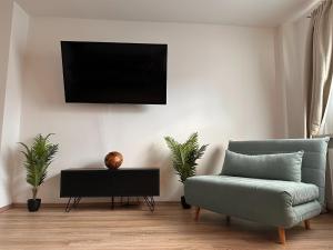 ein Wohnzimmer mit einem Sofa und einem TV an der Wand in der Unterkunft Design Apt. Messe•HBF•Uniklinik in Essen