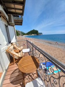 balcón con mesa y sillas en la playa en Beach House, en Petrovac na Moru