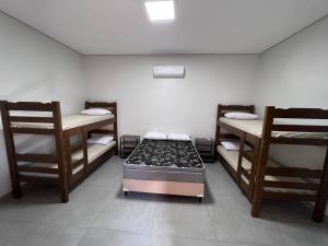 a room with three bunk beds and two chairs at Casa de Temporada Mouton in Olímpia