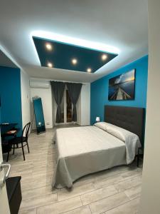 a bedroom with a large bed with a blue wall at Casa vacanze Figurelle in Naples