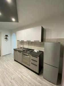 a kitchen with a stove and a refrigerator at Casa vacanze Figurelle in Naples