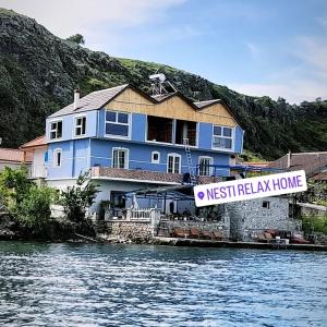 una casa blu con un cartello che legge nishielik home di Nesti Relax Home a Pogradec
