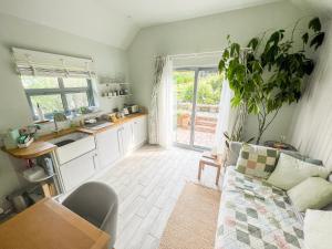 a living room with a couch and a kitchen at Tern Cottage in Groomsport