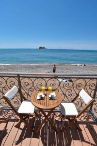 a table and chairs on a balcony overlooking the beach at Beach House in Petrovac na Moru