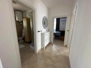 La salle de bains est pourvue de toilettes, d'un lavabo et d'un miroir. dans l'établissement Apartma Zonta, à Sečovlje