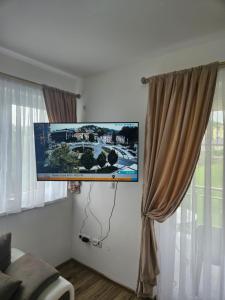 a flat screen tv hanging on a wall next to a window at Golden Sky in Cazin