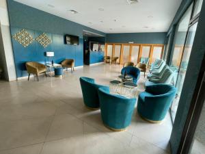 un hall avec des chaises et des tables bleues dans un bâtiment dans l'établissement Hotel Bienestar Termas de Moncao, à Monção
