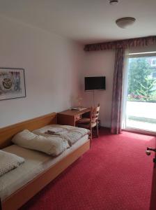 a bedroom with a bed and a desk and a window at Hotel Aura am Schloss in Bad Pyrmont
