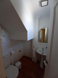 a bathroom with a sink and a toilet and a mirror at Casa con PATIO en el centro de la Ciudad in Chiclana de la Frontera