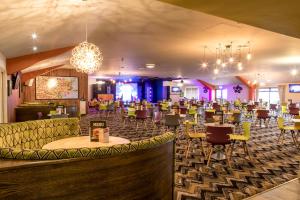 een restaurant met een grote ruimte met tafels en stoelen bij 13 The Meadows New Beach Holiday Park in Kent