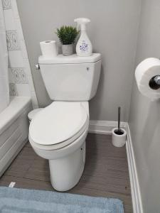 a white bathroom with a toilet and a bath tub at Nathan’s Place in Brampton