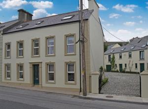 a white building with windows on the side of a street at Mardan House B&B in Killybegs