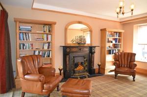 a living room with two chairs and a fireplace at Mardan House B&B in Killybegs