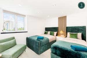 a bedroom with two beds and a couch and a window at Birmingham Central Deluxe Inn in Birmingham