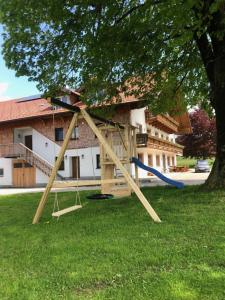 a swing set in a yard next to a tree at Biohof-Feichtinger in Zell am Moos