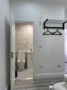 uma porta aberta para uma casa de banho com WC em EAST LONDON APARTMENTS SELF check in em Londres