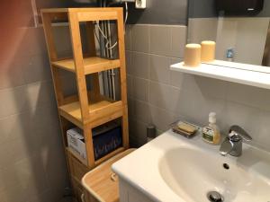 La salle de bains est pourvue d'un lavabo et d'une étagère en bois. dans l'établissement Studio cabine en bord de mer, à La Grande-Motte, à La Grande Motte