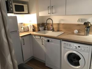 une cuisine avec une machine à laver et un évier dans l'établissement Studio cabine en bord de mer, à La Grande-Motte, à La Grande Motte 24 autres photos