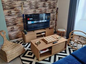 sala de estar con TV de pantalla plana en la pared en Le TROPICA Appartement 2 chambres, plein Sud centre ville de VITRÉ en Vitré