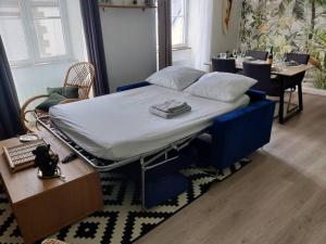 a hospital bed in a room with a table and a dining room at Le TROPICA Appartement 2 chambres, plein Sud centre ville de VITRÉ in Vitré