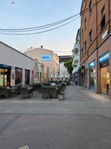 una calle vacía con mesas, sillas y edificios en Emi Luxury Apartments, en Pula