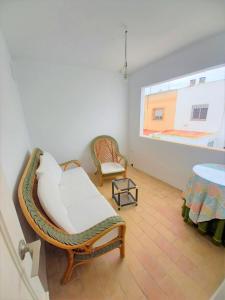 a room with a bed and two chairs and a window at Casa con PATIO en el centro de la Ciudad in Chiclana de la Frontera