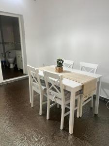 uma mesa branca e cadeiras com um vaso de plantas sobre ela em House Of Beyoutiful Bocsa em Bocşa