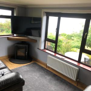 a living room with two windows and a flat screen tv at Stunning Sea view apartment absolute top quality 100s of 5 star reviews You will not be disappointed in Widows Row