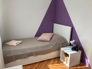 1 dormitorio con 1 cama con pared morada en Family Apartment Bella en Dubrovnik