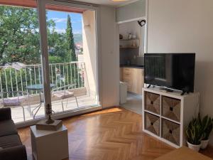 sala de estar con TV y ventana grande en Family Apartment Bella en Dubrovnik