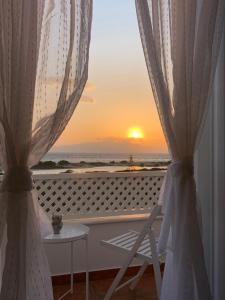 a view of a sunset from a balcony with a chair at Sea and Salt Naxos 3 in Kastraki Naxou