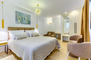 a bedroom with a white bed and a chair at Irini Luxury Rooms in Split