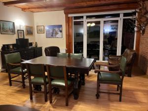 a dining room with a wooden table and chairs at Domek Myśliwski w Spale in Spała