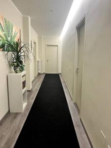 un pasillo con alfombra negra y puerta blanca en Le Dimore di Luciana - suites & apartments, en Lecce