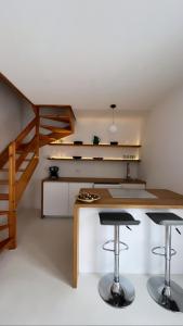 una cocina con 2 taburetes y una escalera en Villa Usignolo, en Lignano Sabbiadoro