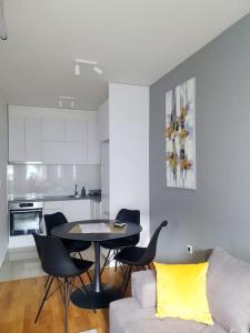 uma cozinha e uma sala de estar com mesa e cadeiras em Sajam 1 em Novi Sad