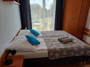łóżko z dwoma ręcznikami na nim przed oknem w obiekcie Dom Gościnny Pola w Rewalu