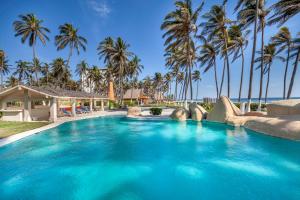 una piscina con palmeras en un complejo en Villas San Vicente, en Acapulco